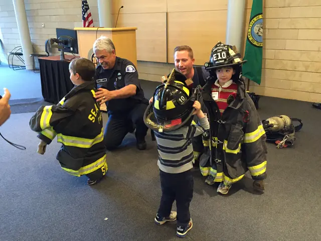 The image shows a group of children in firefighting gear standing next to each other on the floor....