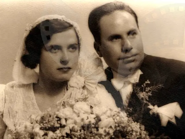 The image shows an old photo of a man and woman on their wedding day. The woman is wearing a white...
