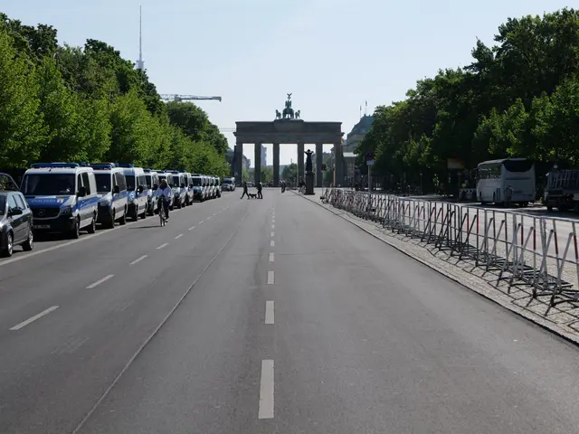 The image shows a long line of police cars parked on the side of a road in front of the Brandenburg...
