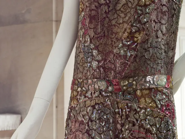 The image shows a mannequin wearing a dress with sequins on it, standing in front of a wall with a...