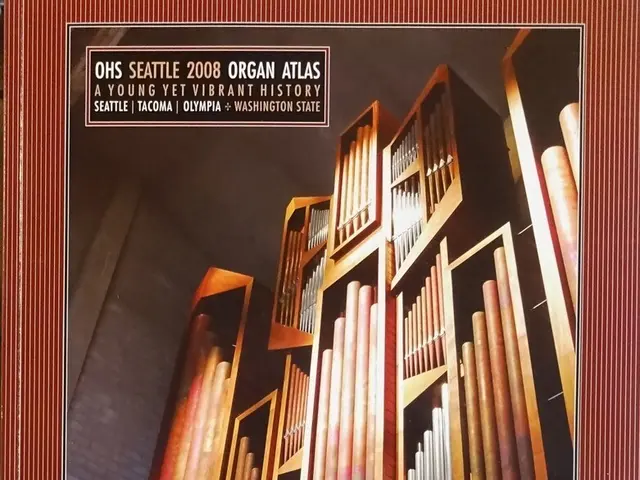 The image shows a book with a picture of a pipe organ on the cover. The book is placed on a flat...