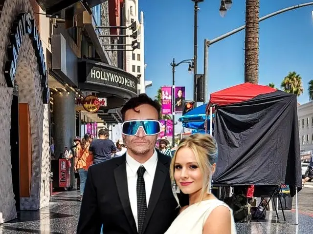 The image shows a man and woman standing next to each other on a Hollywood Walk of Fame. The man is...