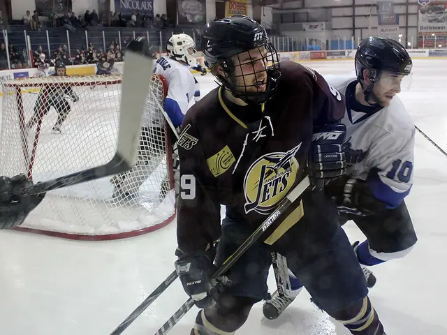 The image shows a group of young men playing a game of ice hockey on an ice rink. They are all...