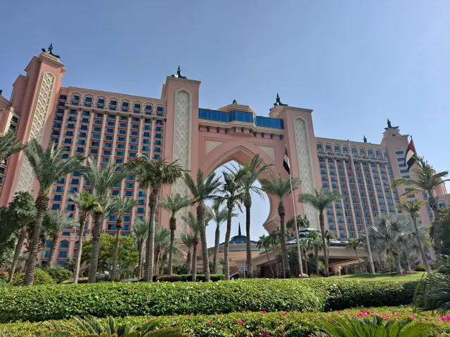 The image shows the Atlantis the Palm Hotel in Dubai, UAE. It is a large building surrounded by...