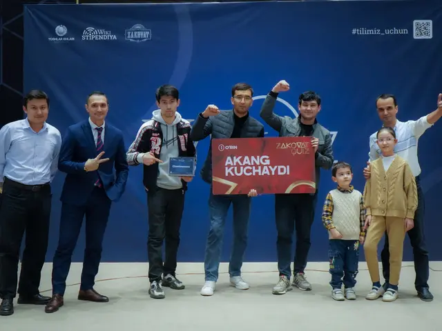 The image shows a group of people standing next to each other on a stage, with two of them holding...