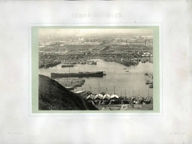 The image shows an old black and white photo of a harbor with boats in the water, surrounded by...