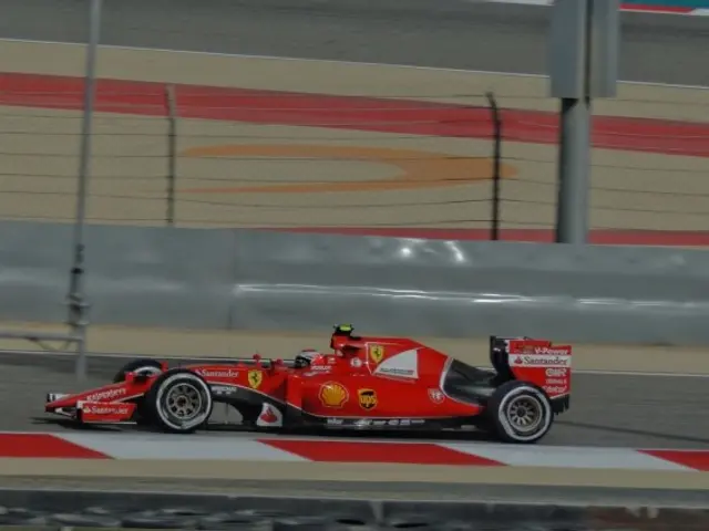 The image shows a Ferrari F1 car driving on a race track, with a person in the driver's seat. The...