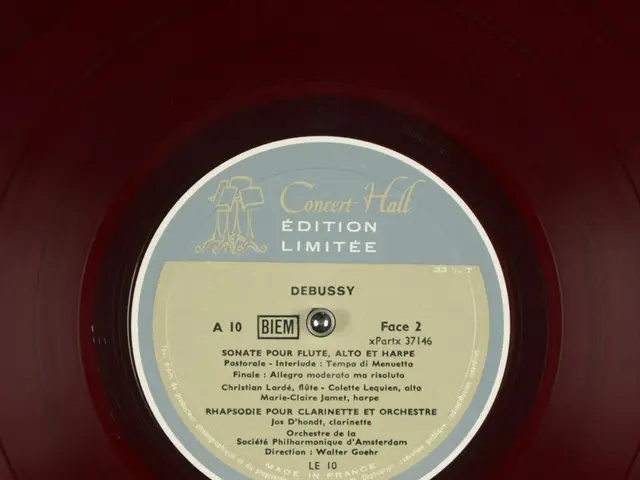 The image shows a red vinyl record with a label on it that reads "Debussy - Concert Hall Edition...