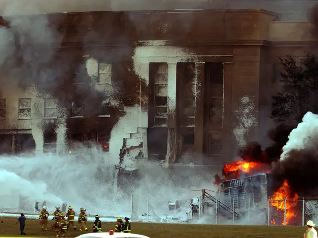 The image shows a large building engulfed in flames and smoke, with firefighters working to put out...
