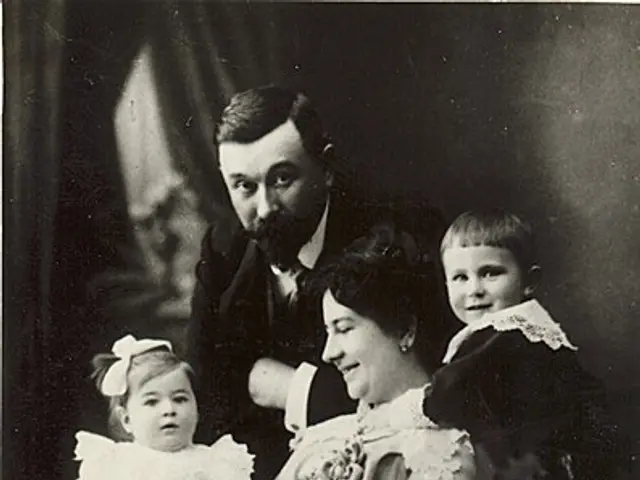 The image shows an old black and white photo of a family posing for a picture. The woman is sitting...