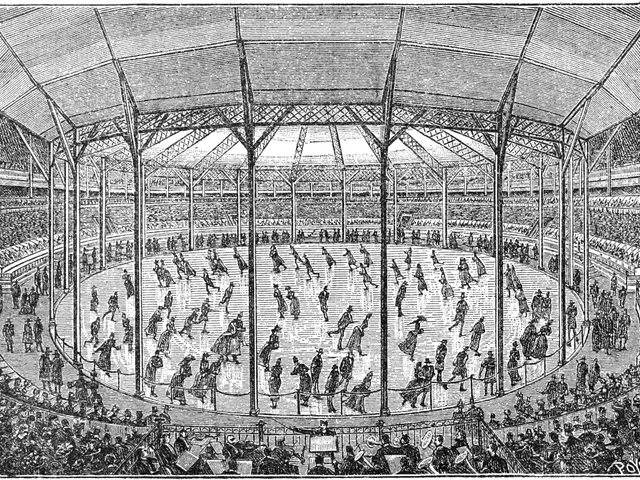 The image shows an old black and white drawing of a large arena with people in it. At the bottom of...