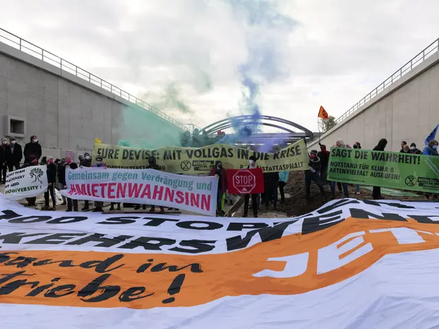 The image shows a group of people standing in front of a large banner with text on it, holding...
