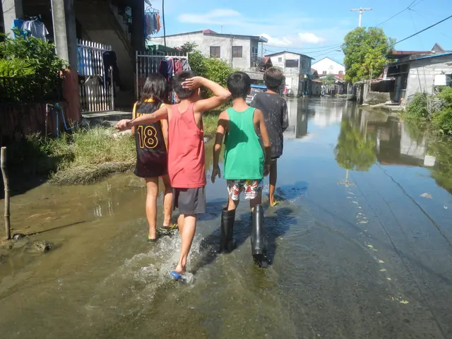 The image shows a group of children wading through a flooded street in Manila, Philippines. The...