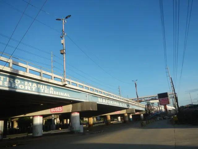 The image shows a tollbooth with a bridge over a road with a sign that reads "Metro Manila...