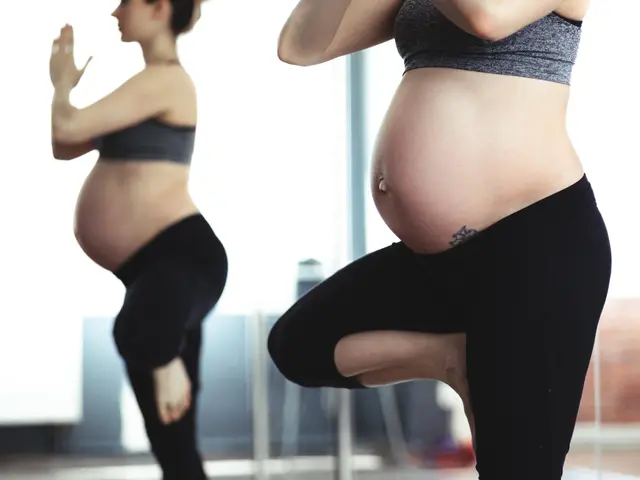 The image shows a pregnant woman in a yoga pose in front of a mirror, with a blurred background....