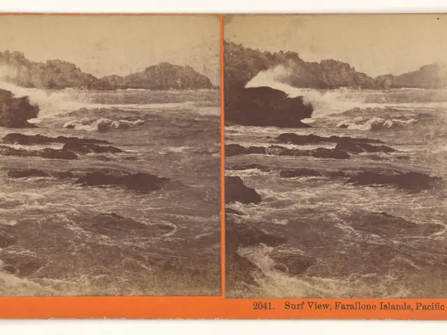 The image shows a black and white photo of waves crashing on rocks in the ocean, with hills in the...