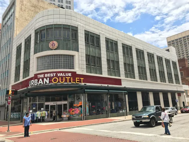 The image shows a bustling city street with vehicles driving on the road and people walking on the...