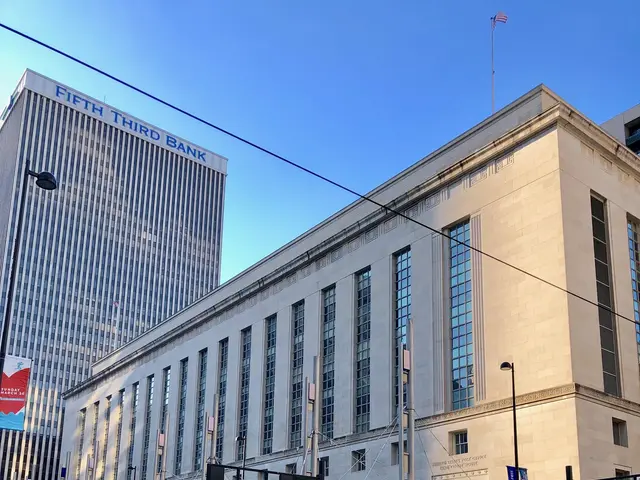 The image shows a bustling city street with vehicles driving on the road, light poles, traffic...