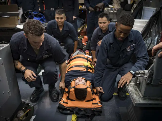 The image shows a group of men in blue uniforms working on a man on a gurney, surrounded by...