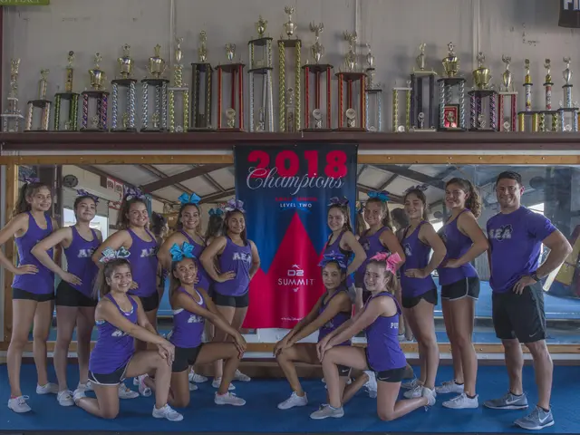 The image shows a group of cheerleaders posing for a photo in front of a display case filled with...