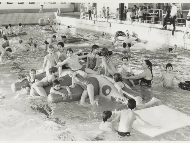The image shows a group of children playing in a swimming pool, with some of them sitting on...