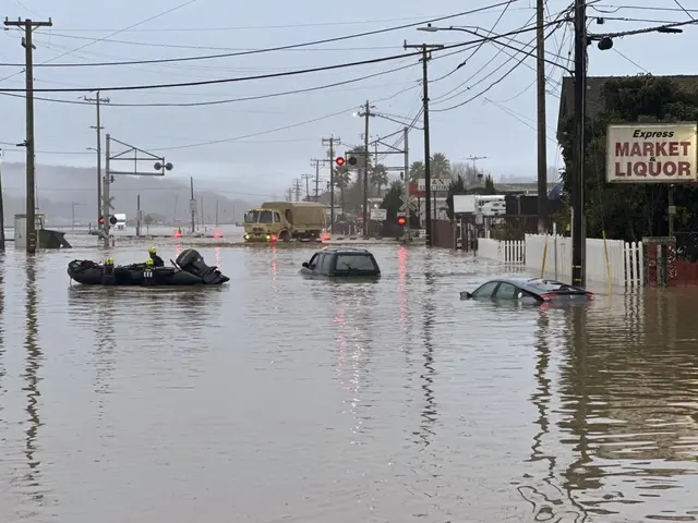The image shows a flooded street with cars and a boat in it, surrounded by electric poles with...