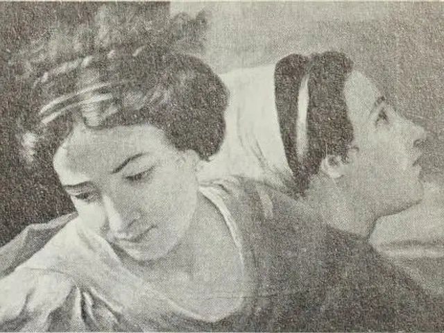 The image shows a black and white photo of two women, one of whom appears to be a mother and the...