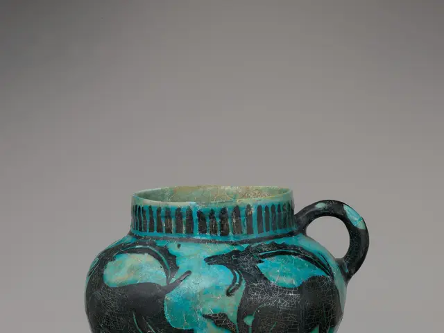 The image shows a terracotta lekythos oil flask with two handles, painted in blue and black,...