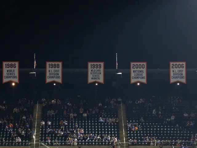 The image shows a baseball stadium filled with lots of people sitting in the stands, illuminated by...