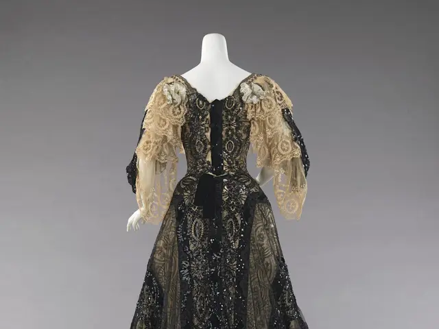 The image shows a mannequin wearing a black and gold evening dress from the Metropolitan Museum of...