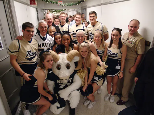 The image shows a group of people posing for a photo with a mascot in the center. The mascot is...
