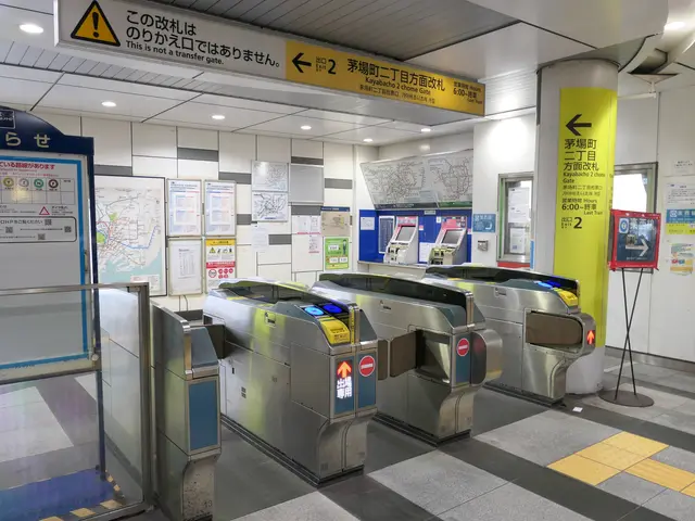 The image shows a subway station with a row of metal turnstiles in the middle of it. On the left...