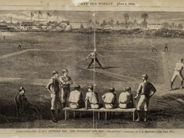 The image shows a group of people playing a game of cricket on a field, with some standing and some...