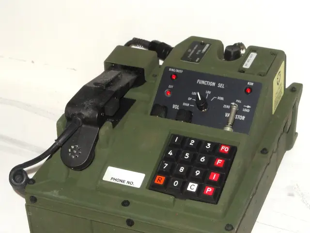 The image shows a green electronic device, a digital subscriber voice terminal, sitting on top of a...