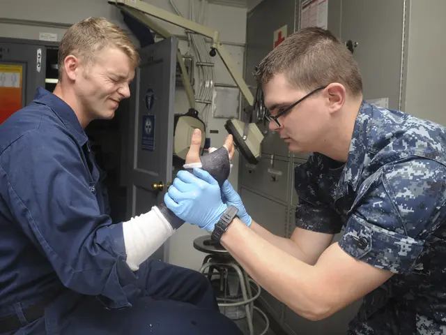 The image shows two men in military uniforms, one sitting on a chair and the other standing beside...
