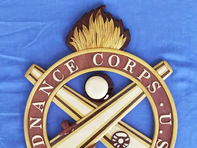 The image shows a wooden plaque with the words "Ordnance Corps" on it, mounted on a blue cloth. The...