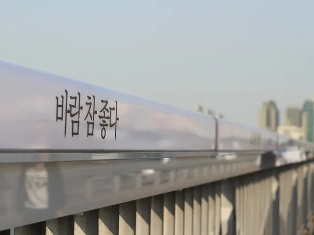 The image shows a train traveling over a bridge with Chinese writing on it. On the right side of...