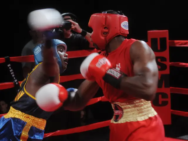 The image shows two boxers fighting in a boxing ring, with a person holding a camera in the...