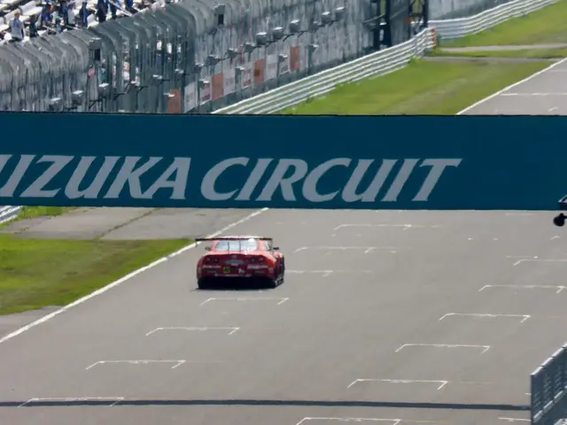 The image shows a red sports car driving down a race track with a sign that reads "Suzuka Circuit"...