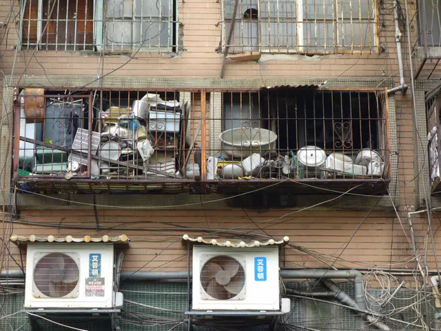 The image shows an apartment building with windows, iron grilles, and air conditioners on the side...