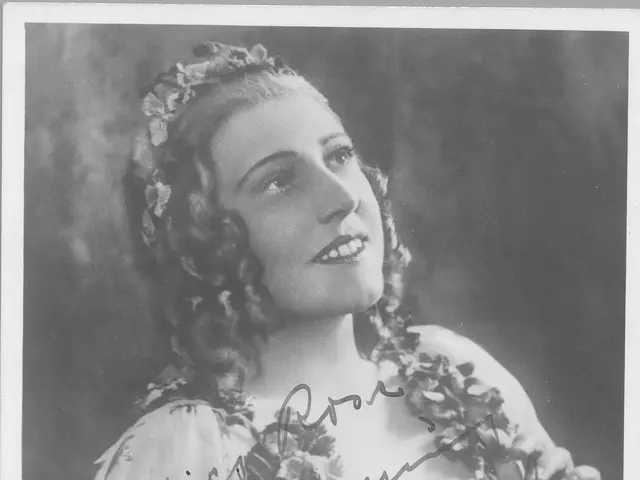 The image shows a black and white photograph of a woman with a warm smile on her face. She is...