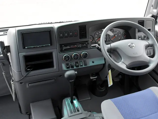 The image shows the interior of a truck with a steering wheel, dashboard, gear rod, seats,...