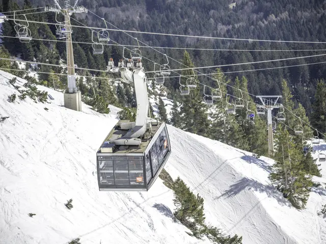 The image shows a cable car going up a snowy mountain with trees in the background. The cable car...