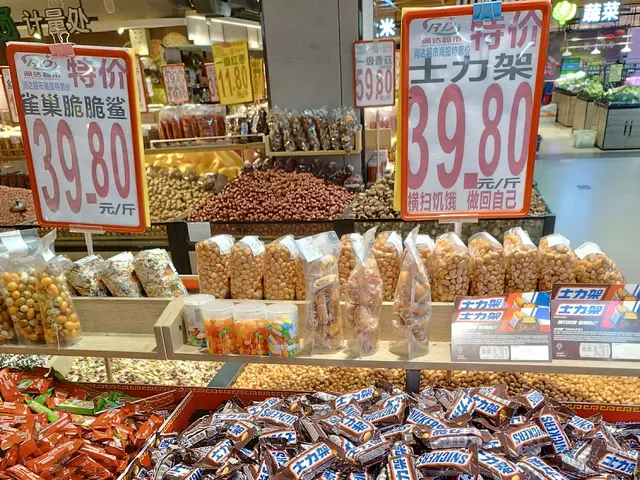 The image shows a display case filled with lots of different types of candy, including Snickers, in...