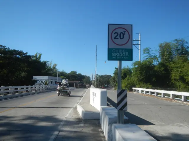 The image shows a car driving across a bridge with a speed limit sign on it. The bridge has...
