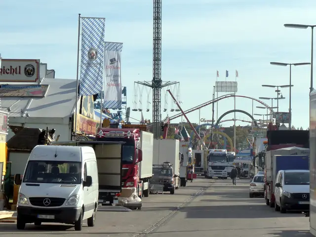 The image shows a busy street filled with lots of trucks and cars. There are people walking on the...