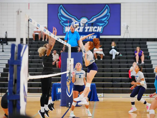 The image shows a group of women playing a game of volleyball, with a net in the middle and people...