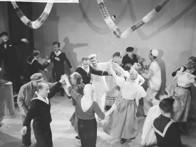 The image shows a group of people dancing on a dance floor in front of a wall adorned with...