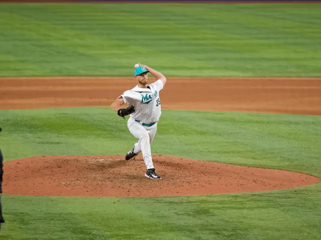 The image shows a baseball player pitching a ball on top of a field. The player is wearing a sports...