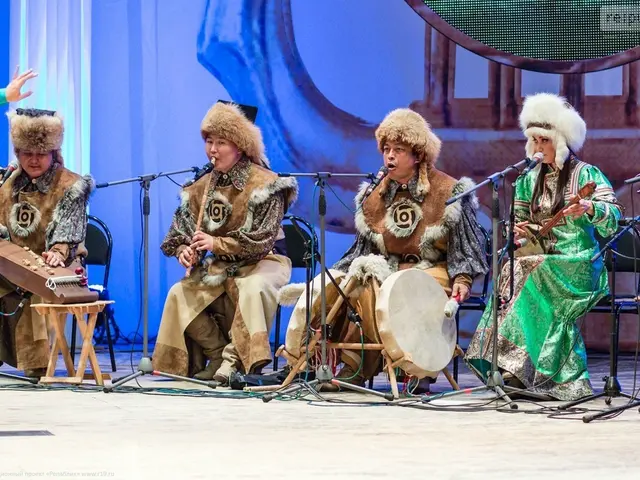 The image shows a group of people sitting on top of a stage, wearing caps and playing various...
